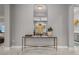 Hallway decor: a gold framed table topped with art pieces is backed by a modern mirror at 13319 Deep Blue Pl, Bradenton, FL 34211