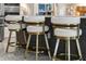 Close-up of the modern kitchen island featuring bar stools with gold accents and a sleek, minimalist design at 13319 Deep Blue Pl, Bradenton, FL 34211