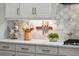 White cabinets and marble backsplash with knife rack, plant and coffee mugs at 13319 Deep Blue Pl, Bradenton, FL 34211