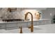 Close-up shot of a kitchen sink with a gold faucet and white countertops at 13319 Deep Blue Pl, Bradenton, FL 34211