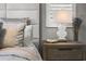 Nightstand with lamp, next to bed with cushioned headboard and shuttered window at 13319 Deep Blue Pl, Bradenton, FL 34211