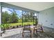 Relaxing screened-in patio area with stone pavers and comfortable rocking chairs overlooking greenery at 13319 Deep Blue Pl, Bradenton, FL 34211