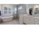 Luxurious bathroom with a soaking tub, glass shower, dual sinks, and white cabinetry at 14210 9Th Ne Ter, Bradenton, FL 34212