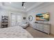 Bright bedroom featuring a ceiling fan, white walls, a dresser with a TV, and a sitting area at 14210 9Th Ne Ter, Bradenton, FL 34212