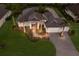 Exterior view of the home with mature trees, tropical landscaping, tile roof and paver driveway at 14210 9Th Ne Ter, Bradenton, FL 34212