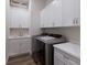 Organized laundry room with white cabinets, quartz countertops, a sink, and modern washer and dryer units at 14210 9Th Ne Ter, Bradenton, FL 34212