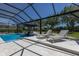 Backyard pool with lounge chairs and clear blue water, surrounded by a screened enclosure and lush landscaping at 14210 9Th Ne Ter, Bradenton, FL 34212