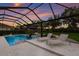 Screened pool with lounge chairs, umbrella, and a view of lush landscaping at 14210 9Th Ne Ter, Bradenton, FL 34212