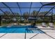 Beautiful backyard pool with lounge chairs, mature landscaping, and clear blue water under a screened enclosure at 14210 9Th Ne Ter, Bradenton, FL 34212