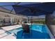 Relaxing pool area with a navy umbrella, clear blue water, and a nearby covered seating area for ultimate outdoor enjoyment at 14210 9Th Ne Ter, Bradenton, FL 34212