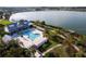 Aerial view of a luxurious community pool and lake, surrounded by lush landscaping and elegant buildings at 16148 Preservation Blvd, Punta Gorda, FL 33982