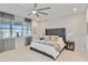 Comfortable bedroom with a luxurious tufted headboard, ceiling fan and lake views at 16148 Preservation Blvd, Punta Gorda, FL 33982