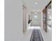 Bright hallway with light tile, a sliding barn door, and a decorative runner at 16148 Preservation Blvd, Punta Gorda, FL 33982