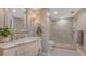 Well-lit bathroom with a marble vanity, walk-in shower, and modern fixtures, with light tile flooring at 1701 Gulf Of Mexico Dr # 502, Longboat Key, FL 34228