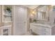 Elegant bathroom with a marble vanity, decorative mirror and a storage cabinet at 1701 Gulf Of Mexico Dr # 502, Longboat Key, FL 34228