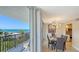 Elegant dining area with a modern light fixture and stunning ocean views from the adjacent balcony at 1701 Gulf Of Mexico Dr # 502, Longboat Key, FL 34228