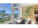 Bright home office featuring a modern desk and beach views through expansive windows at 1701 Gulf Of Mexico Dr # 502, Longboat Key, FL 34228
