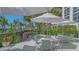 Relaxing outdoor patio with grill, tables, chairs, and tropical landscaping at 1701 Gulf Of Mexico Dr # 502, Longboat Key, FL 34228