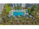 Overhead shot of pool with palms, manicured landscaping, lounge chairs, and aqua colored umbrellas at 1701 Gulf Of Mexico Dr # 502, Longboat Key, FL 34228