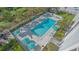 Aerial view of a pool area surrounded by palm trees and lounge chairs with beach access at 1701 Gulf Of Mexico Dr # 502, Longboat Key, FL 34228