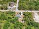 Aerial view of the home surrounded by trees, driveway and outdoor living space at 1709 Kerman St, North Port, FL 34288