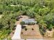 Aerial view of the home features mature trees, long driveway, and serene surroundings at 1709 Kerman St, North Port, FL 34288