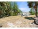 Expansive backyard featuring mature trees, outdoor seating and patio perfect for relaxing and entertaining at 1709 Kerman St, North Port, FL 34288