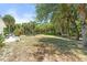 Large backyard with mature trees, outdoor seating, a grill, and a cozy hammock between the trees at 1709 Kerman St, North Port, FL 34288