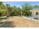 Expansive backyard with outdoor seating, a grill, mature trees, and a well-manicured lawn at 1709 Kerman St, North Port, FL 34288