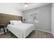 Bright bedroom featuring light gray walls, wood-look floors, and headboard with a modern design at 1709 Kerman St, North Port, FL 34288