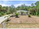 Spacious home exterior with well-maintained lawn and mature trees at 1709 Kerman St, North Port, FL 34288