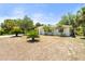 Inviting home exterior with a well-maintained lawn and lush tropical landscaping with plenty of palm trees at 1709 Kerman St, North Port, FL 34288