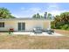 Rear patio area with outdoor seating and a grill, offering a cozy space for relaxation and entertaining at 1709 Kerman St, North Port, FL 34288