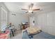 A neutral-toned bedroom with a ceiling fan, closet space, desk, and a comfortable bed at 1723 Fred Ives St, Ruskin, FL 33570