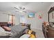 Well-lit primary bedroom features a ceiling fan, a comfy bed, dresser, creating a serene space for rest and relaxation at 1723 Fred Ives St, Ruskin, FL 33570