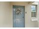 Charming blue front door featuring a festive holiday wreath and smart lock, providing a welcoming entry at 1723 Fred Ives St, Ruskin, FL 33570