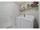 Functional laundry room with washer, dryer, shelving and tile floor, offering convenience and storage space at 1723 Fred Ives St, Ruskin, FL 33570