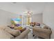 Bright living room features a ceiling fan, neutral paint, comfortable seating, and an entertainment center at 1723 Fred Ives St, Ruskin, FL 33570
