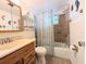 Bathroom featuring a single sink vanity, toilet, and shower with brown tile surround and a curtain at 1819 Restful Dr # N25, Bradenton, FL 34207