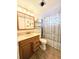 Bathroom featuring a single sink vanity, toilet, and shower with brown tile surround and a curtain at 1819 Restful Dr # N25, Bradenton, FL 34207