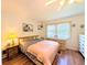 Bedroom featuring hardwood floors, ceiling fan, window with blinds, and two dressers at 1819 Restful Dr # N25, Bradenton, FL 34207