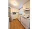 Galley kitchen with stainless steel refrigerator and white appliances and cabinetry at 1819 Restful Dr # N25, Bradenton, FL 34207