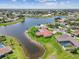 Wide aerial showcases a property backing onto a lake, complete with a private dock and beautifully landscaped grounds at 1836 Ironwood Ct, Venice, FL 34293