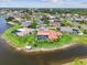 Aerial shot of a home with a red roof and screened pool surrounded by lush landscaping and lake views at 1836 Ironwood Ct, Venice, FL 34293