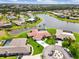 Stunning aerial view of a beautiful home with a red tile roof, pool and lush landscaping, backing onto a lake at 1836 Ironwood Ct, Venice, FL 34293