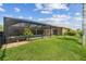 Landscaped backyard with view of the screened pool at 1836 Ironwood Ct, Venice, FL 34293