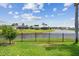 Grassy backyard with lake view with black metal fence at 1836 Ironwood Ct, Venice, FL 34293