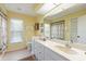 Well-lit bathroom with vanity, large mirror and neutral tile flooring at 1836 Ironwood Ct, Venice, FL 34293