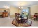 Bright dining room features a modern glass table, elegant chandelier, and ample natural light at 1836 Ironwood Ct, Venice, FL 34293