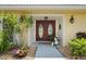 Elegant double front doors with decorative glass panels are framed by lush landscaping and warm exterior lighting at 1836 Ironwood Ct, Venice, FL 34293